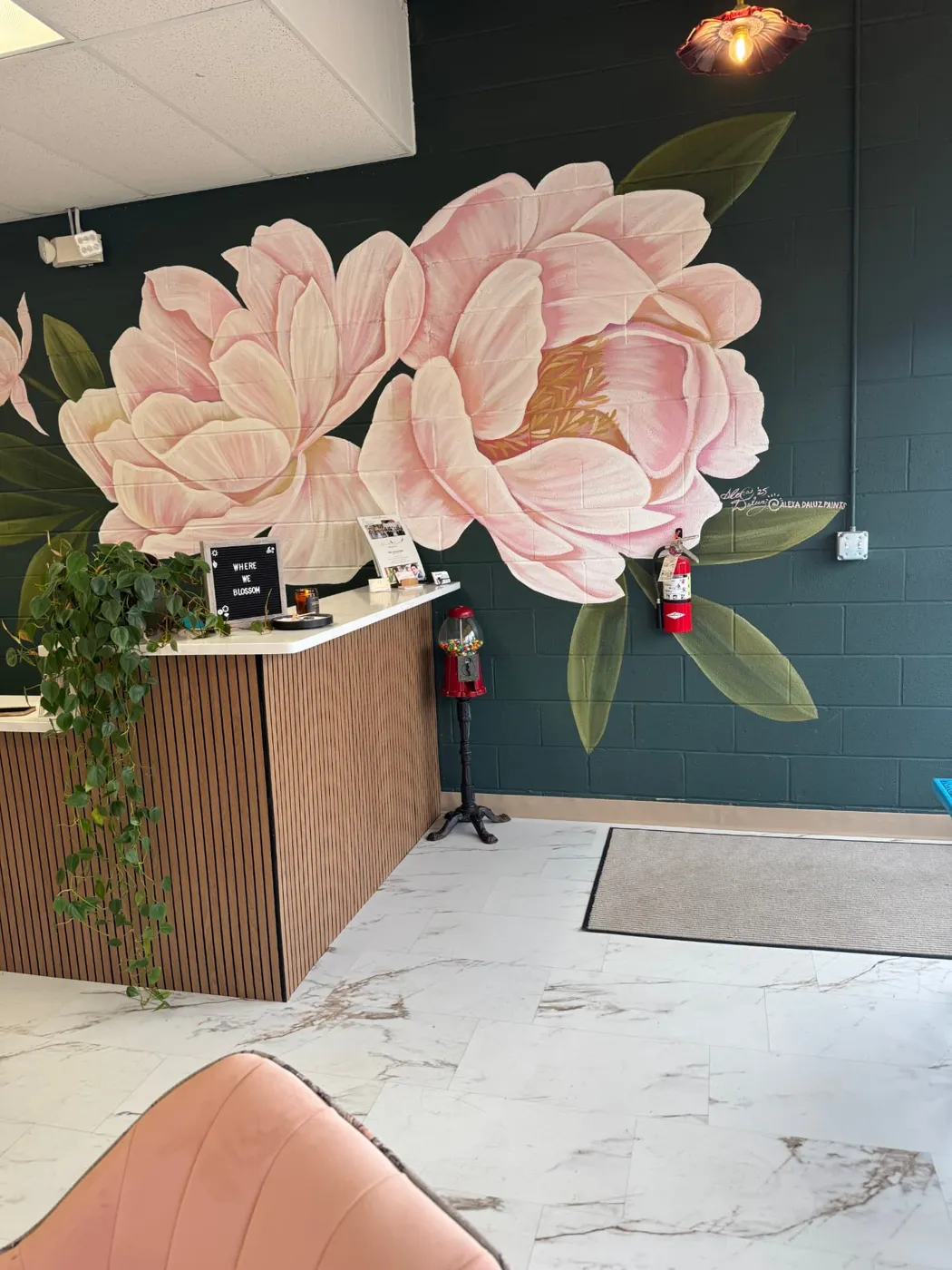 Hand-painted peony mural behind the reception desk at Blossom Beauty Bar